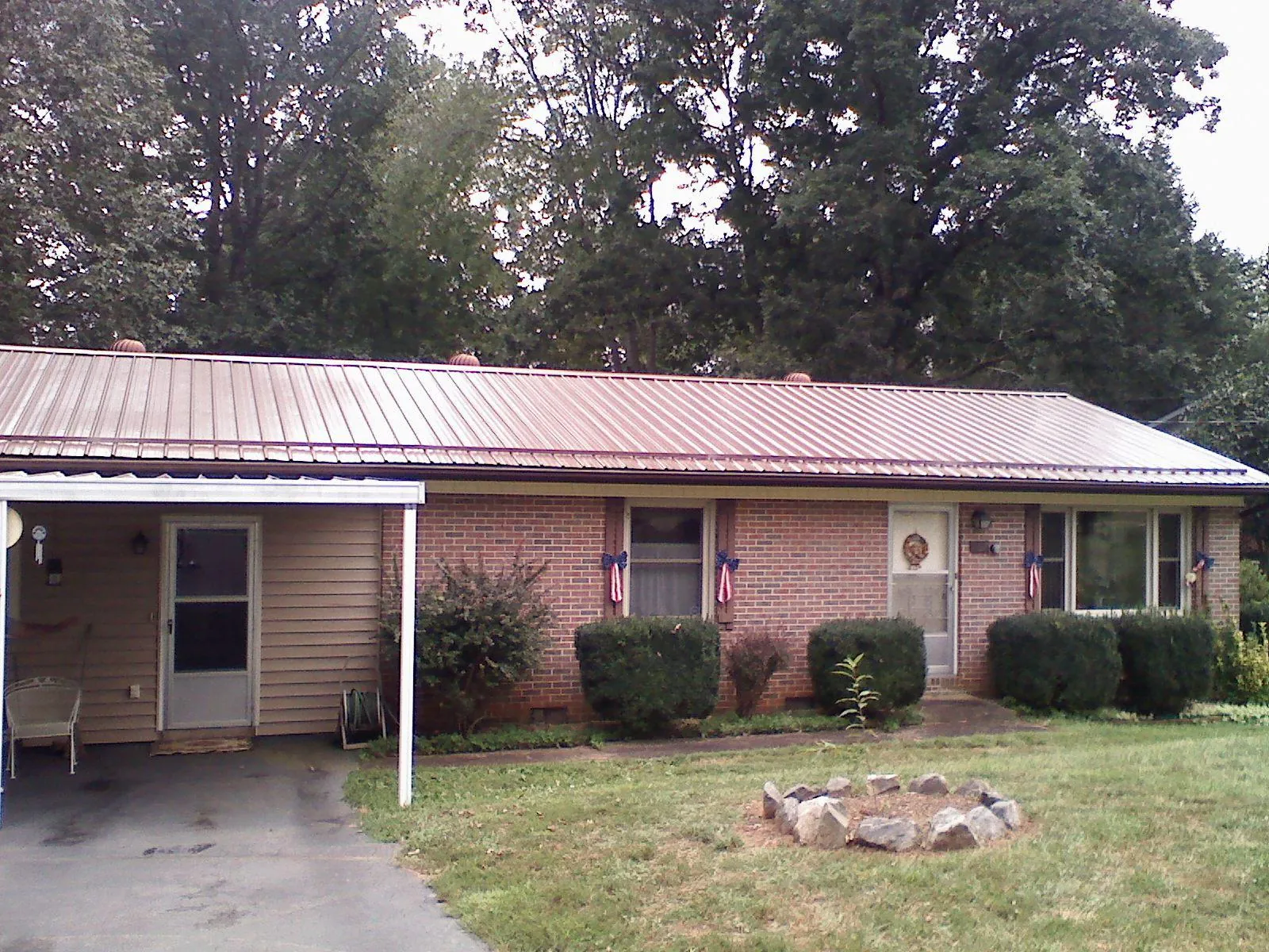 Bronze metal roof and carport on a brick ranch home — Roof Repair work by our crew in Parker